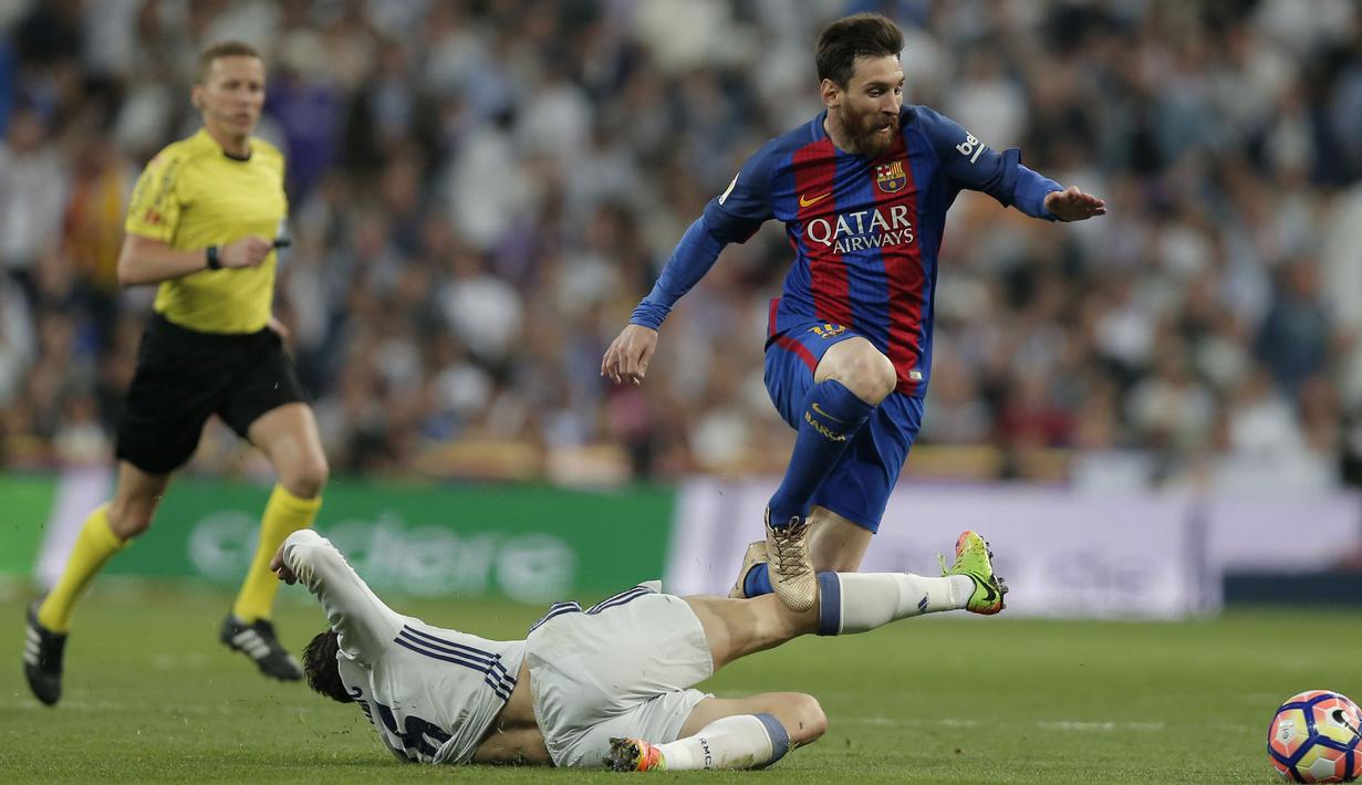Lionel Messi melompat menghidari terjangan pemain Real Madrid, Mateo Kovacic pada duel El Clasico di Santiago Bernabeu stadium, Madrid, Spanyol, Minggu, (23/4/2017). Barcelona menang 3-2.  (AP/Daniel Ochoa de Olza)