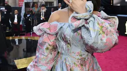 Penyanyi Andra Day menyapa para penggemarnya sesaat sebelum berjalan di karpet merah penghargaan Piala Oscars 2018 di Dolby Theatre, Los Angeles, Minggu (4/3). Andra Day menyempurnakan penampilannya dengan clutch abu-abu. (Charles Sykes/Invision/AP)