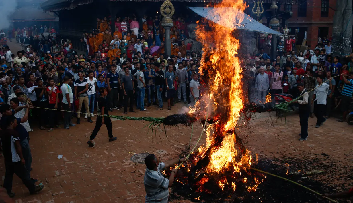 Umat Hindu Nepal membakar patung jerami dalam perayaan Ghanta Karna di Bhaktapur di pinggiran Kathmandu, Nepal (21/7). Menurut cerita setempat, setan Ghanta Karna suka menculik anak-anak dan perempuan. (AFP Photo/Gopen Rai)
