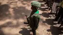 Tentara anak yang baru dibebaskan berdiri dengan senapan pada sebuah upacara di Yambio, Sudan Selatan, (7/2). Anak-anak ini secara resmi telah dilucuti senjatanya dan diberikan pakaian sipil. (AFP PHOTO/Stefanie Glinski)