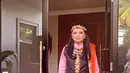 Yanti Airlangga tampil dengan baju Dayak dari atasan hitam vest dengan motif bordiran khas Dayak. Dipadukan inner kemeja pink lengan panjang, serta bawahan rok orange bermotif dayak. Lengkap membawa tas handbag dengan beads beraksen Dayak. [@yanti.airlangga]