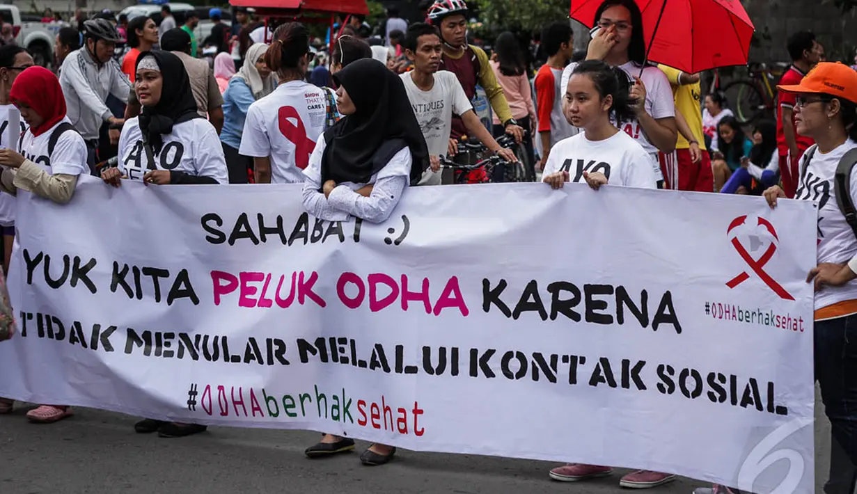 Dalam aksinya mereka menentang diskriminasi terhadap orang yang terjangkit HIV AIDS dan memberikan sosialisasi kepada masyarakat penularan HIV AIDS tidak melalui kontak badan, Jakarta, Minggu (28/12/2014). (Liputan6.com/Faizal Fanani)
