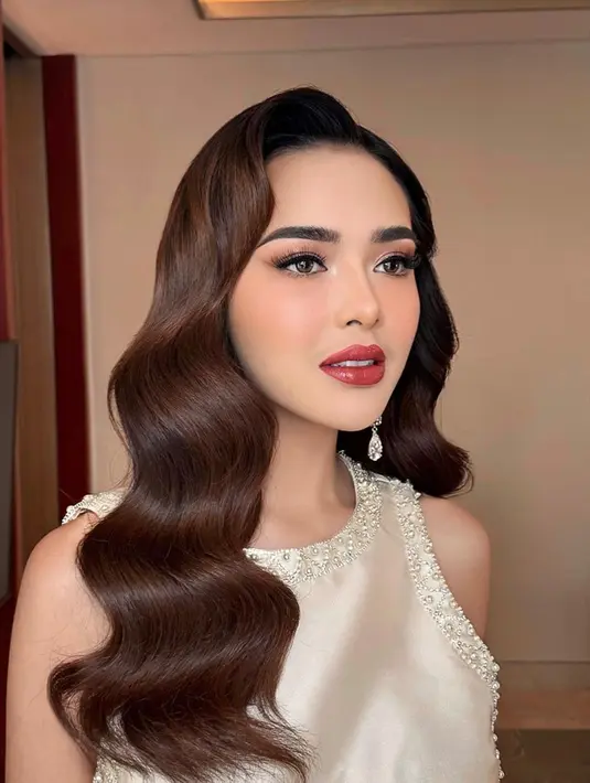 Wajah Amanda Manopo dipoles dengan bold makeup, namun tetap terlihat natural. Lipstik merah dan perona pink membuat penampilannya makin fresh. Sementara itu, rambut panjangnya juga ditata rapi dengan gaya berombak, membuat pesonanya makin terpancar. (Liputan6.com/IG/@jooehair)