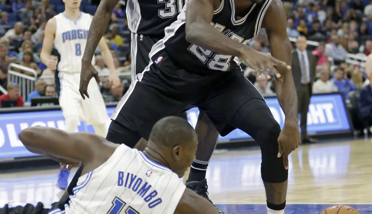 Pemain Spurs, Livio Jean-Charles #28 berebut bola dengan pemain Orlando Magic, Bismack Biyombo #11 pada laga NBA preseason basketball di Orlando. (AP/John Raoux)