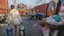 Penjual chai (teh) India berjalan melewati pasar grosir buah dan sayuran di New Delhi (27/3). Karena tidak semua orang mampu berbelanja di mal atau toko bermerek, sebagian besar penduduk lebih pergi ke pasar jalanan. Kualitas barang bervariasi dari pasar ke pasar. (AFP Photo/Noemi Cassanelli)