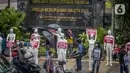 Aktivis membawa manekin dengan poster saat menggelar aksi di depan Polda Metro Jaya, Senin (21/3/2022). Aksi tersebut bentuk dukungan terhadap Haris Azhar dan Fatia Maulidiyanti saat menjalani pemeriksaan terkait kasus dugaan pencemaran nama baik Luhut Binsar Pandjaitan. (Liputan6.com/Faizal Fanani)