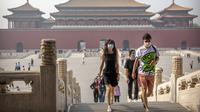 Para pengunjung mengenakan masker saat berjalan di Kota Terlarang, Beijing, China, Jumat (1/5/2020). Kota Terlarang kembali dibuka setelah ditutup lebih dari tiga bulan karena pandemi virus corona COVID-19. (AP Photo/Mark Schiefelbein)