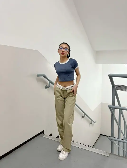 Naura Ayu berpose saat berada di tangga dengan crop top dan celana panjang. Gayanya anak muda banget ya. [instagram/naura.ayu]