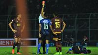 Bek PSM Makassar, Hasyim Kipuw, menerima kartu merah dari wasit Thoriq Alkatiri, dalam laga kontra Arema FC di Stadion Kanjuruhan, Malang, dalam laga pekan ke-22 Shopee Liga 1 2019, Rabu (2/10/2019). (Bola.com/Iwan Setiawan)