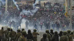 Demonstran saat bentrok dengan polisi anti huru hara di Quito (7/10/2019). Massa demonstran di Ekuador juga menyerbu gedung parlemen dalam lanjutan aksi protes kenaikan harga BBM hingga 100 persen. (AFP Photo/Rodrigo Buendia)