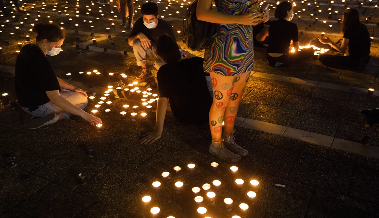 Warga menyalakan lilin pada peringatan 25 tahun pembunuhan Perdana Menteri Israel Yitzhak Rabin, di Rabin Square, Tel Aviv, Kamis (29/10/2020). Yitzhak Rabin ditembak ekstremis Yahudi, Yigal Amir usai melakukan pidato perdamaian Kings of Israel Square pada 4 November 1995. (AP Photo/Oded Balilty)