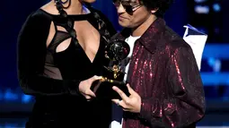 Penyanyi Bruno Mars menerima trofi Record of the Year dari Alicia Keys pada ajang Grammy Awards 2018 di New York City, Minggu (28/1). Dengan album 24K Magic, Bruno merebut enam trofi Grammy termasuk Record of the Year. (Kevin Winter/Getty Images/AFP)