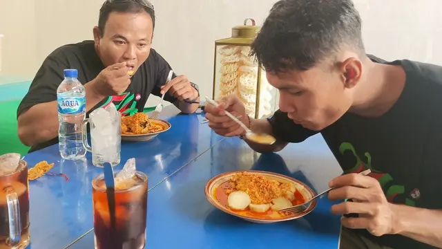 Pengunjung asal Blora, Lilik (kiri) dan Helmi (kanan) ketika menyantap kuliner Lontong Mbleyer. (Liputan6.com/Ahmad Adirin)