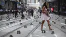 Seorang wanita berjalan melewati batu bata yang ditempatkan  demonstran untuk menghalangi jalan selama protes di distrik keuangan di Hong Kong (14/11/2019). (AP Photo/Vincent Yu)