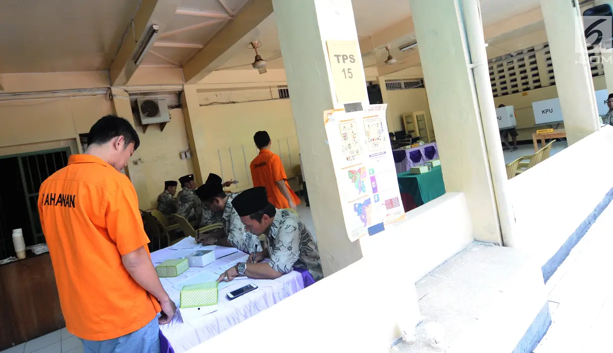 Tahanan melihat informasi kandidat capres-cawapres dan para caleg sebelum mencoblos di TPS 15 Rutan Polda Metro Jaya, Jakarta, Rabu (17/4). Para tahanan Rutan Polda Metro Jaya melakukan pencoblosan di dua lokasi yakni TPS 14 dan TPS 15. (Liputan6.com/Herman Zakharia)