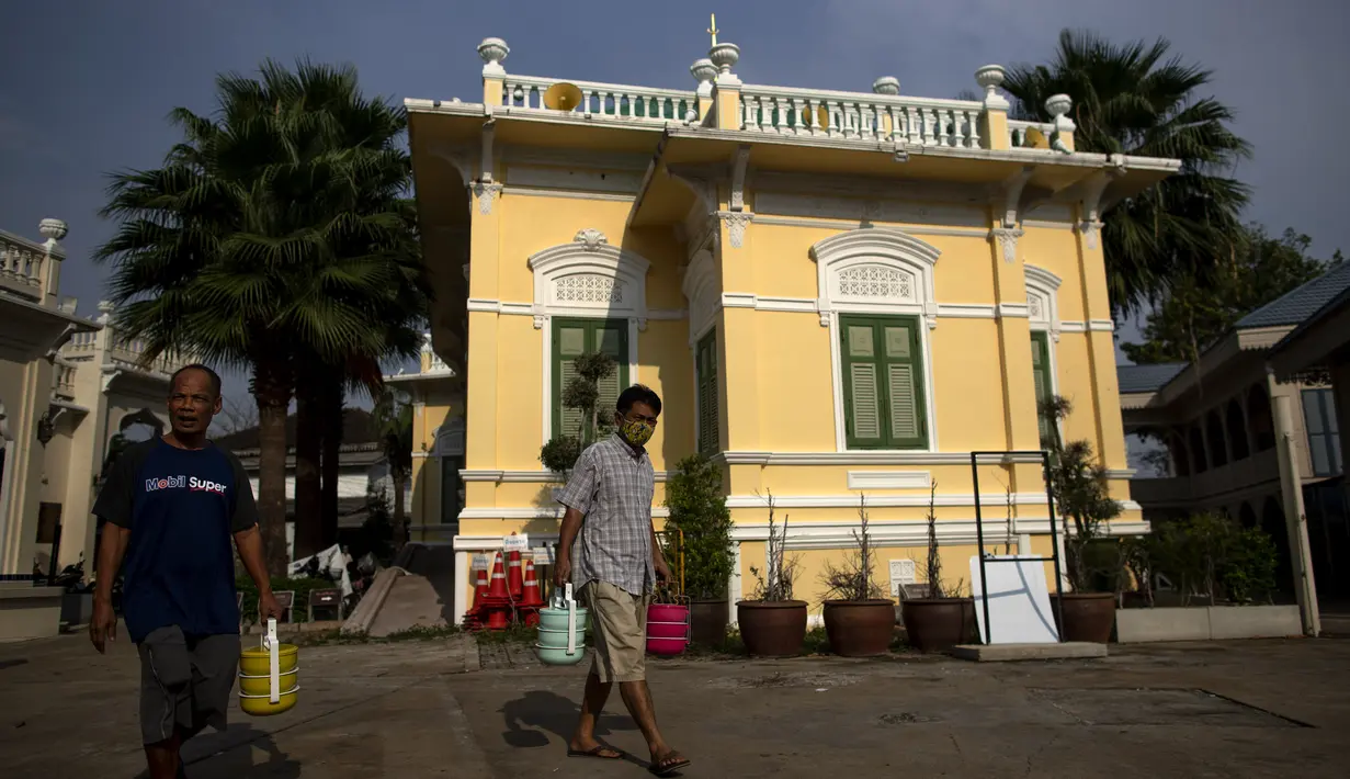 Umat muslim membawa kotak berisi makanan dari Masjid Bang Aw, Bangkok, Thailand, Kamis (30/4/2020). Setiap hari selama Ramadan, sukarelawan membagikan makanan kepada 150 keluarga sekitar Masjid Bang Aw yang tidak bisa beribadah bersama karena pandemi COVID-19. (AP Photo/Gemunu Amarasinghe)