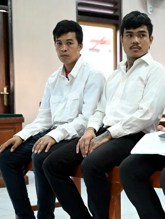 Warga negara Thailand, Prakob Seetasang (kiri) dan Adison Phonlamat (tengah) saat menjalani persidangan kasus penyelundupan narkoba di pengadilan Denpasar, Bali (23/9/2019). Jaksa menuntut 2 pria Thailand tersebut dengan hukuman penjara 18 tahun. (AFP Photo/Sonny Tumbelaka)