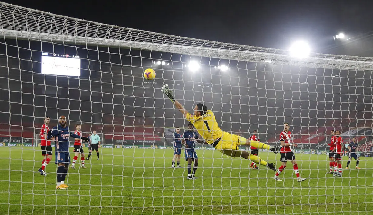 Penjaga gawang Southampton Alex McCarthy gagal menghentikan bola saat pemain Arsenal Nicolas Pepe mencetak gol ke gawangnya pada pertandingan Liga Inggris di Stadion St Mary, Southampton, Inggris, Selasa (26/1/2021). Arsenal menang 3-1 atas Southampton. (AP Photo/Frank Augstein, Pool)