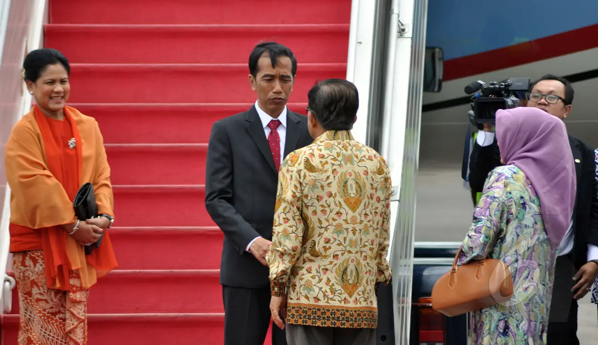 Presiden Jokowi (kedua kanan) berbincang dengan Wapres Jusuf Kalla (kanan) disaksikan Ibu Negara, Iriana (ketiga kanan) sebelum menaiki pesawat kepresidenan di Bandara Halim Perdanakusuma, Jakarta, Minggu (22/3). (Liputan6.com/Faizal Fanani)