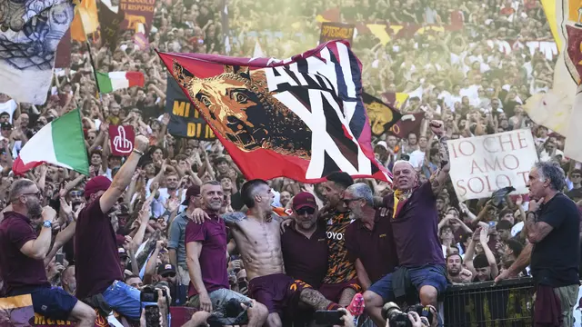 Pemain AS Roma, Gianluca Mancini (tengah kiri) dan Lorenzo Pellegrini (tengah kanan), merayakan kemenangan bersama para suporter