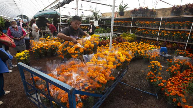 Orang-orang berbelanja bunga marigold di Xochimilco, Mexico City, Meksiko, Rabu (14/10/2020). Panen bunga marigold Meksiko yang dikenal sebagai Cempasuchil dalam bahasa Nahuatl dilakukan jauh-jauh hari sebelum hari libur Day of the Dead. (AP Photo/Marco Ugarte)