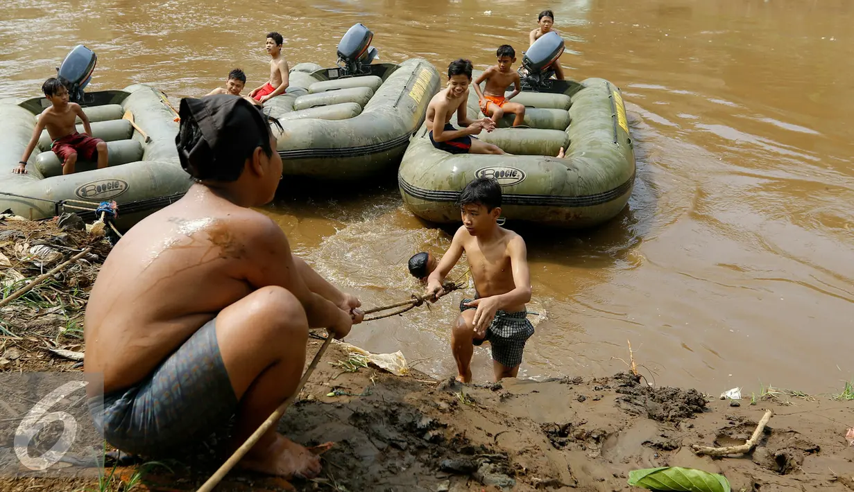 Anak-anak Ciliwung saat berada di kapal kecil di sungai Ciliwung, Jakarta, Jumat (13/11). Tanpa rasa takut, anak-anak Ciliwung terjun ke aliran sungai dari atas jembatan Kalibata yg tingginya mencapai 7-8 meter. (Liputan6.com/Yoppy Renato)