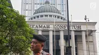 Polisi berjaga menjelang sidang perdana MK Pemilu 2019 di halaman depan Gedung Mahkamah Konstitusi, Jakarta, Jumat, (14/6/2019). Sekitar 30 ribu pesonil gabungan diterjunkan untuk mengawal jalannya sidang. (Liputan6.com/Johan Tallo)
