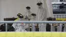 Petugas medis menunggu sampel pengemudi dengan gejala virus corona (COVID-19) di Goyang, Korea Selatan, Minggu (1/3/2020). Hingga 4 Maret 2020 sore, jumlah kematian akibat virus corona di Korea Selatan menjadi 33 orang. (Kim Hyun-tae/Yonhap via AP)
