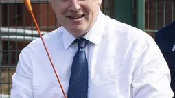 PM Inggris Boris Johnson bermain panahan saat mengunjungi Premier Education Summer Camp di Sacred Heart of Mary Girl's School, Upminster, Inggris, Senin (10/8/2020). Kunjungan Boris untuk melihat persiapan jelang pembukaan kembali sekolah pada September mendatang. (Lucy Young/Pool via AP)