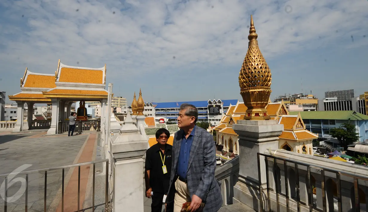 Pengunjung memasuki kawasan kuil Golden Budha di kota Bangkok, Thailand, Sabtu (17/12). Salah satu biksu yang ada di kuil tersebut memprediksi hasil laga final kedua Piala AFF 2016 antara Thailand melawan Indonesia. (Liputan6.com/Helmi Fithriansyah)