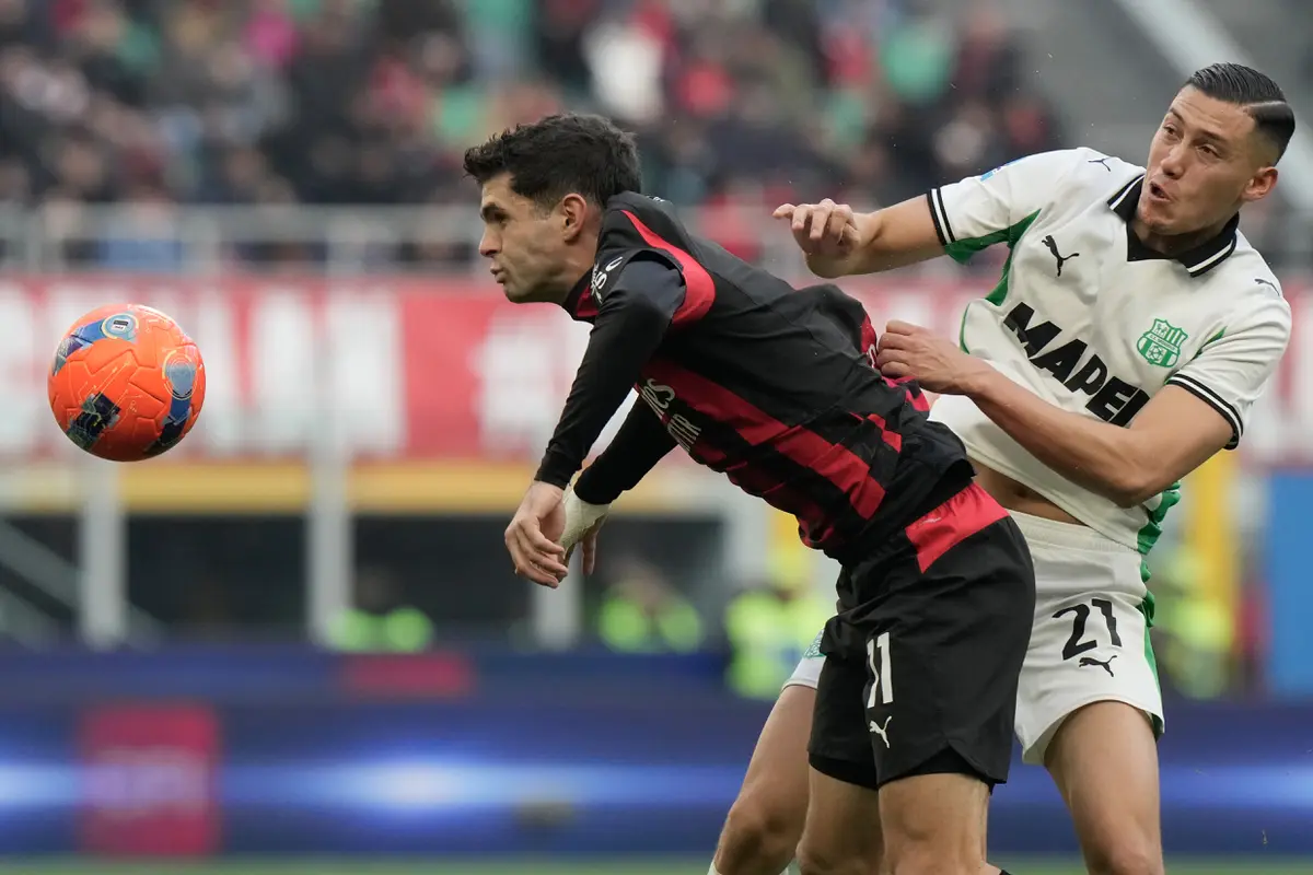 Christian Pulisic (kiri) berduel dengan Jay Idzes di laga AC Milan vs Sassuolo di pekan ke-15 Serie A 2025/2026 di San Siro, Minggu (14/12/2025). (AP Photo/Luca Bruno)