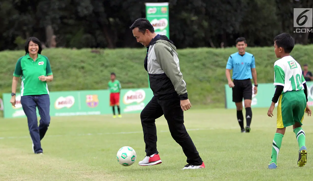 Menteri Pemuda dan Olahraga, Imam Nahrawi menggiring bola pada acara kompetisi sepak bola U-12 antar Sekolah Dasar, MILO Football Championship 2018, di Senayan, Jakarta, Sabtu (24/3). Kompetisi diikuti lebih dari 8.000 siswa SD. (Liputan6.com/Pool/Rizky)