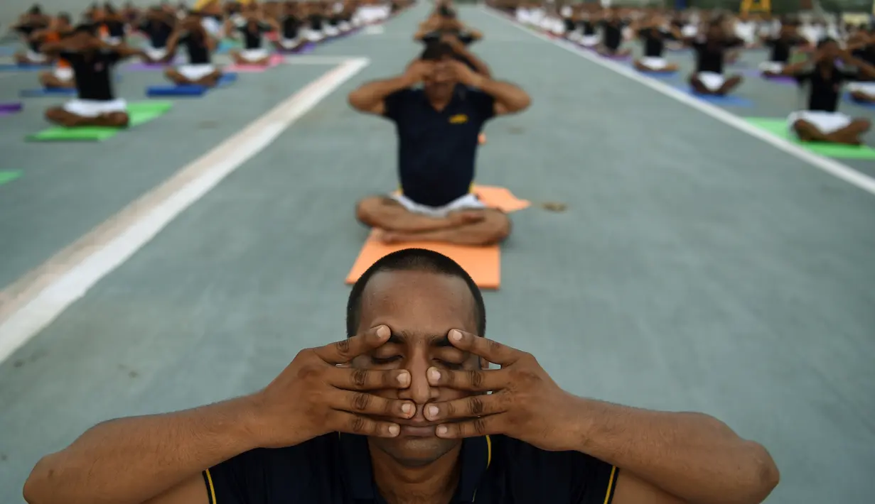Personel Angkatan Laut India melakukan gaya yoga di atas kapal induk INS Viraat di Mumbai, India, (21/6). PM Narendra Modi mengatakan 21 Juni dirinya dan jutaan orang di seluruh dunia merayakan Hari Yoga Internasional. (AFP Photo/Punit Paranjpe)