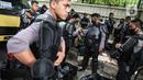 Personel Brimob bersiap mengenakan perlengkapan pelindung diri di Kawasan Bundaran HI, Jakarta, Selasa (13/10/2020). Sebanyak kurang lebih 12 ribu personel gabungan TNI, Polri dan Pemprov DKI Jakarta diterjunkan mengawal aksi tolak Undang-Undang Cipta Kerja Omnibus Law. (Liputan6.com/Faizal Fanani)