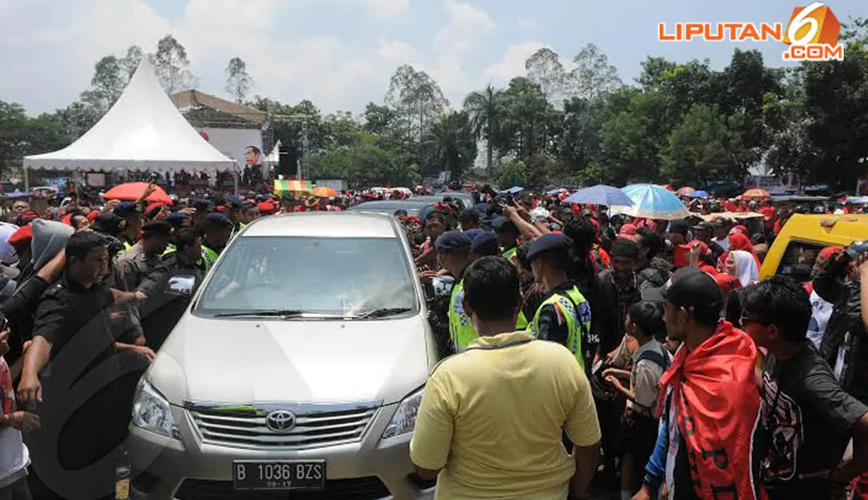 Beberapa petugas tampak menghalau para simpatisan yang menghalangi jalan Jokowi saat akan meninggalkan lapangan (Liputan6.com/Herman Zakharia)