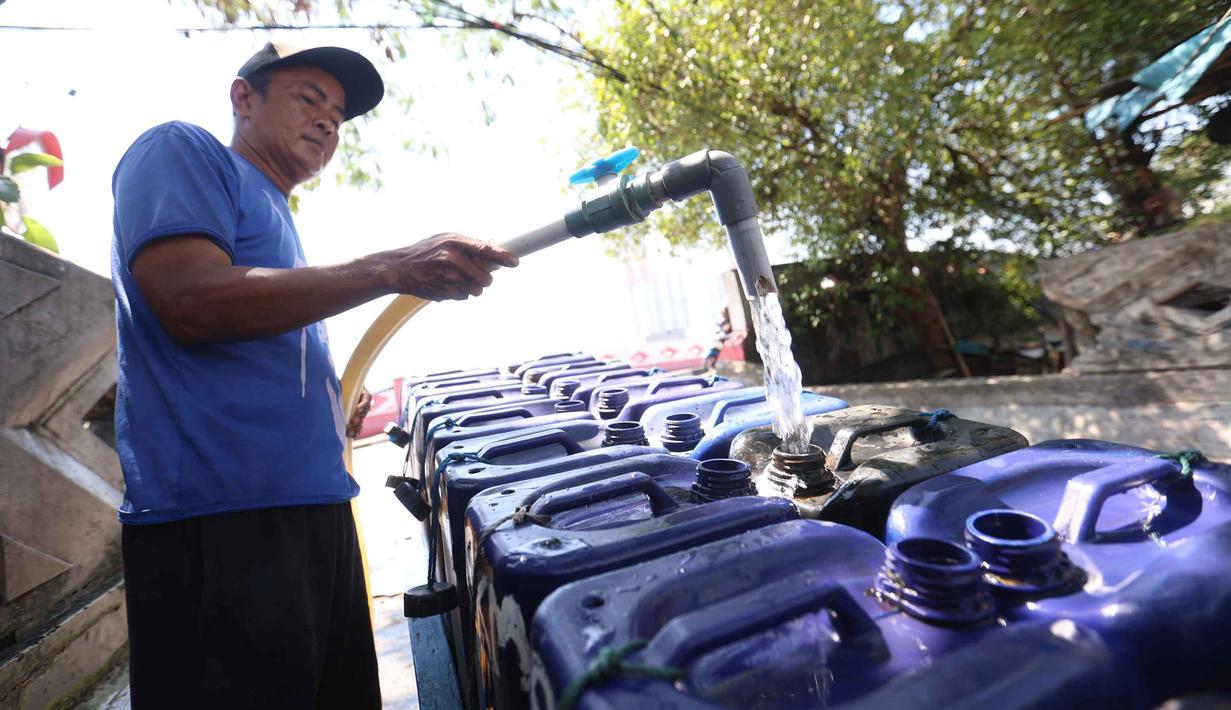 Pedagang mengisi jeriken dengan air bersih untuk segera didistribusikan kepada pelanggan di Kawasan Muara Angke, Jakarta, Kamis (28/5/2026). (Kapanlagi.com/Budy Santoso)
