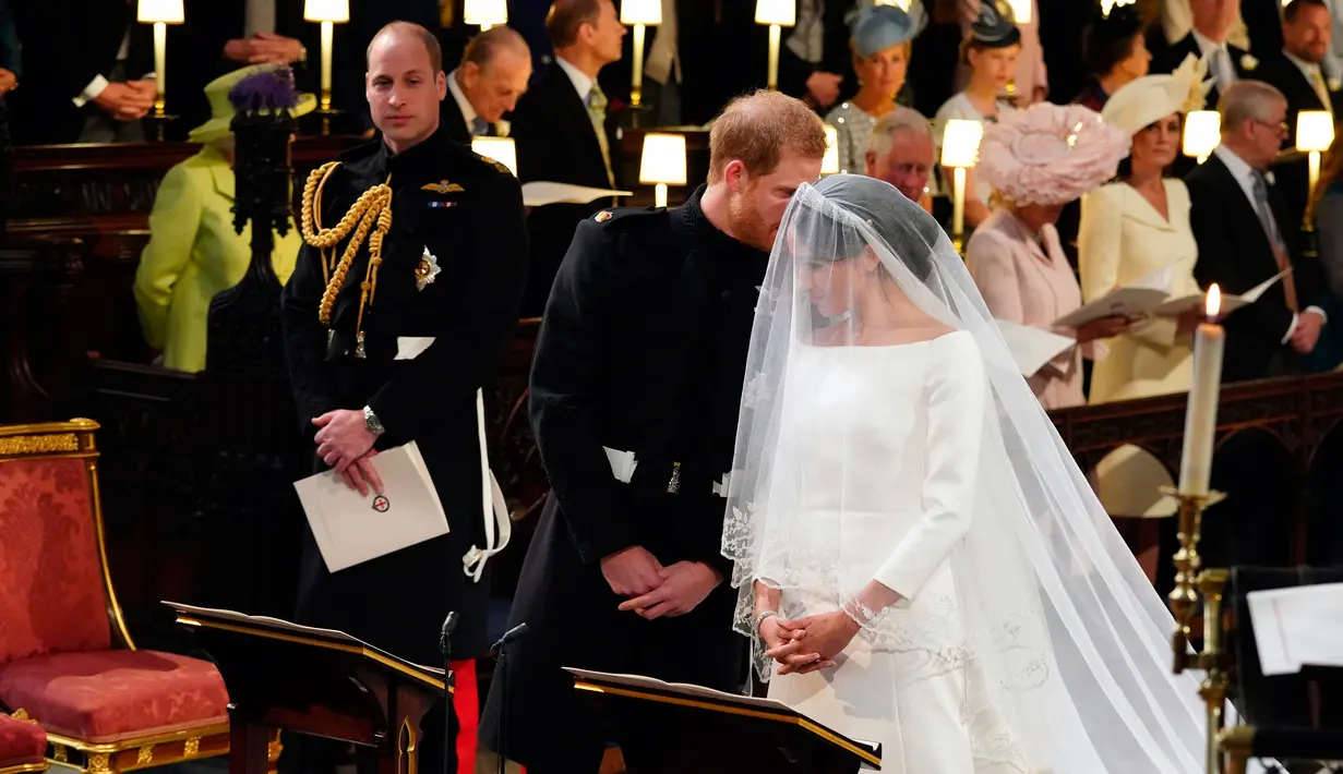 Pangeran Harry berbicara kepada Meghan Markle saat prosesi pernikahan mereka di Kapel St. George, Kastil Windsor, Inggris, Sabtu (19/5). Pangeran Harry dan Meghan Markle resmi menjadi suami istri. (Gareth Fuller/pool photo via AP)