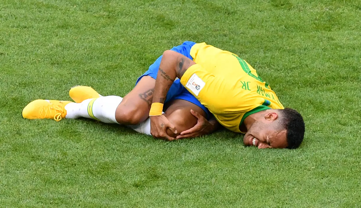 Penyerang timnas Brasil, Neymar mengerang kesakitan di atas lapangan pada babak 16 besar Piala Dunia 2018 melawan Meksiko di Samara Arena, Senin (2/7). Neymar dinilai bersikap berlebihan saat dijatuhkan lawan dalam duel di lapangan. (AFP/SAEED KHAN)