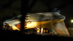 Penyelidik bekerja di lokasi jatuhnya pesawat Antonov An-26 di Bandara Almaty, Kazakhstan, Sabtu (13/3/2021). Kementerian Situasi Darurat Kazakhstan mengonfirmasi insiden tersebut menewaskan empat dari enam orang di dalamnya. (Abduaziz MADYAROV/AFP)