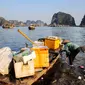 Dalam foto file yang diambil pada 17 Mei 2023 tampak seorang pekerja memungut sampah dari Ha Long Bay di timur laut Vietnam.&nbsp;(Nam NGUYEN/AFP)