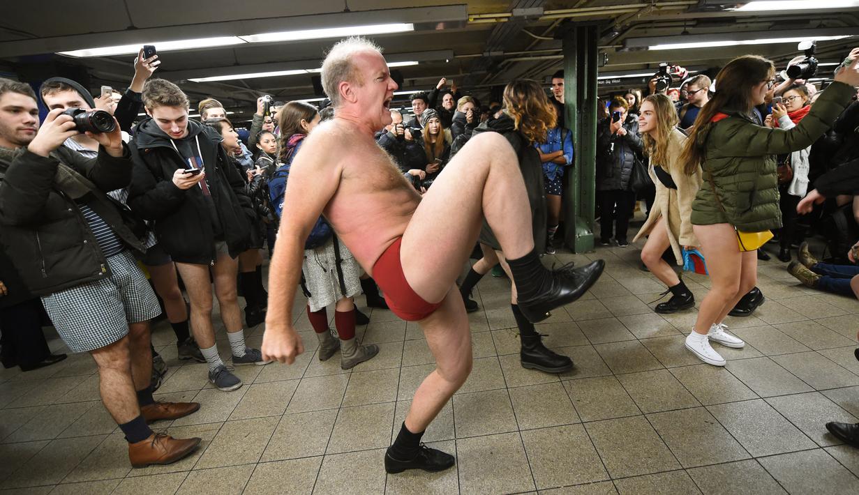 Peserta berjoged saat berpartisipasi dalam "No Pants Subway Ride" di atas platform kereta bawah tanah New York City, USA (10/1//2016). Acara ini dimulai pada tahun 2002 dengan peserta hanya tujuh orang. (AFP PHOTO/TIMOTHY A. Clary)