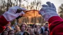 Acara tahunan ini berlangsung pada Sabtu 4 April 2026, saat senja di sebuah taman alam di pinggiran kota Kyiv, Ukraina. Tampak dalam foto, seorang sukarelawan dari pusat rehabilitasi kelelawar Ukraina menunjukkan sayap kelelawar yang diselamatkan kepada orang-orang sebelum melepaskan kelelawar tersebut kembali ke alam liar di Kyiv, Ukraina, Sabtu, 4 April 2026. (AP Photo/Dan Bashakov)