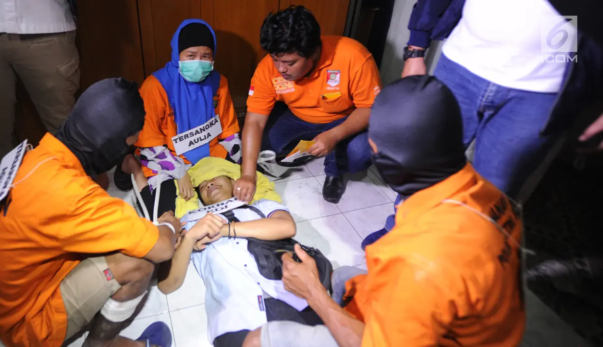 Tersangka Aulia Kesuma (dua kiri) saat rekonstruksi pembunuhan suami dan anak tirinya di Jalan Lebak Bulus 1, Cilandak, Jakarta Selatan, Kamis (5/9/2019). Aulia menghabisi nyawa Edi Chandra Purnama alias Pupung Sadili dan anaknya M. Adi Pradana alias Dana di rumah ini. (merdeka.com/Arie Basuki)