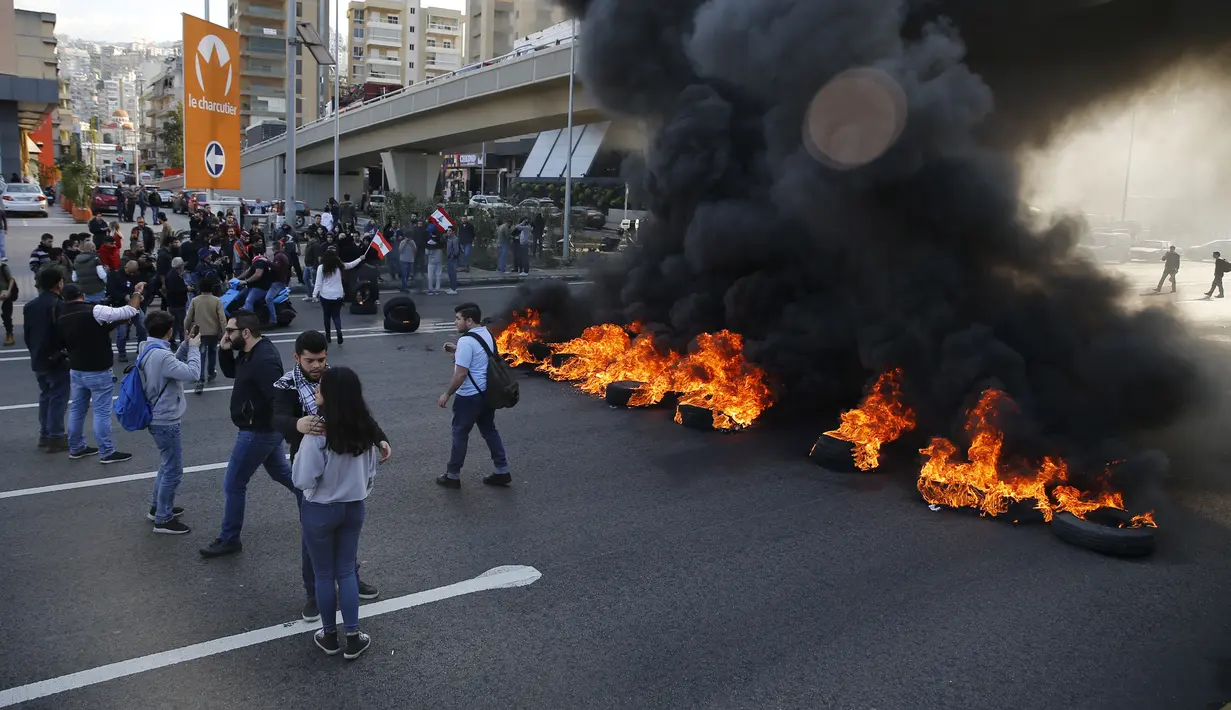 Demonstran antipemerintah membakar ban saat protes menentang elite penguasa di Kota Jal el-Dib, Lebanon, Selasa (14/1/2020). Demonstran menganggap elite penguasa gagal mengatasi ekonomi yang menurun tajam. (AP Photo/Bilal Hussein)