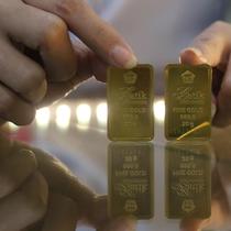 Petugas menunjukkan sampel logam mulia di Butik Emas Antam, Jakarta, Kamis, (23/7/2020). Usai cetak rekor ke posisi termahalnya di Rp 982 ribu, harga emas PT Aneka Tambang Tbk (Emas Antam) kembali turun Rp 5.000 menjadi Rp 977 ribu per gram pada perdagangan hari ini. (Liputan6.com/Angga Yuniar)