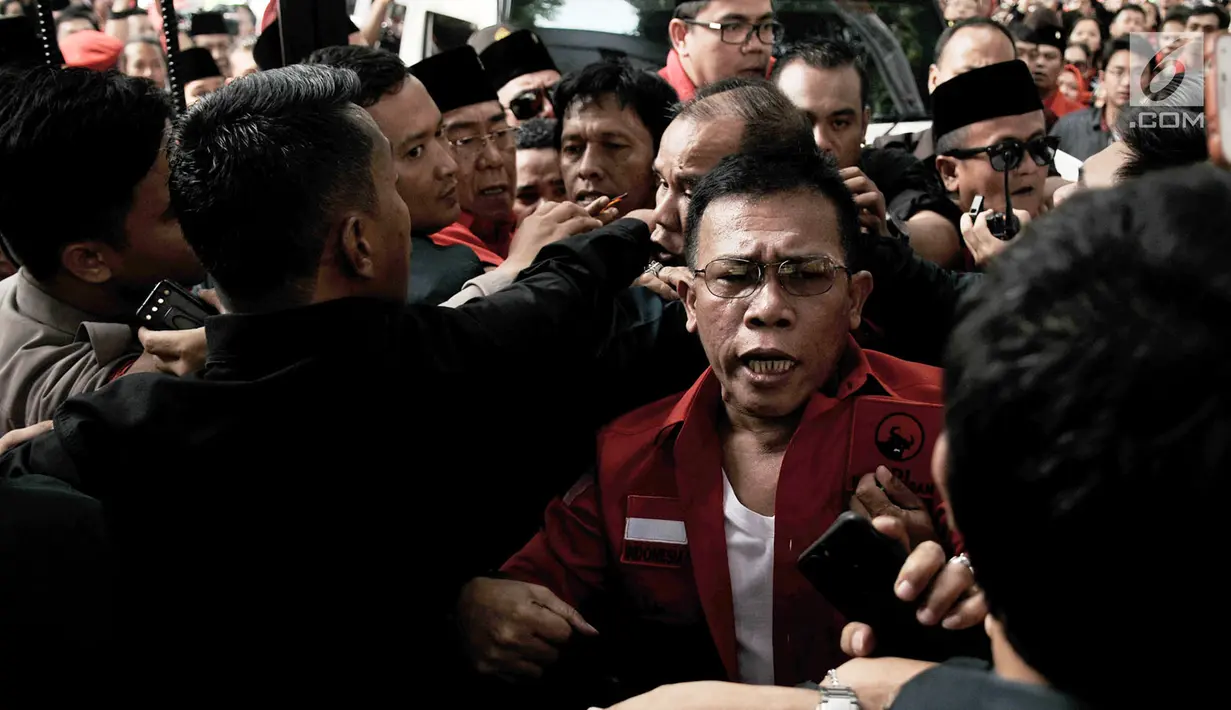 Kader PDIP Masinton Pasaribu saling dorong dengan petugas saat hendak masuk ke Gedung KPU, Jakarta, Selasa (17/7). Elite serta massa PDIP terlibat kericuhan saat hendak mengantarkan pengurus DPP mendaftarkan bakal caleg. (Merdeka.com/ Iqbal S. Nugroho)