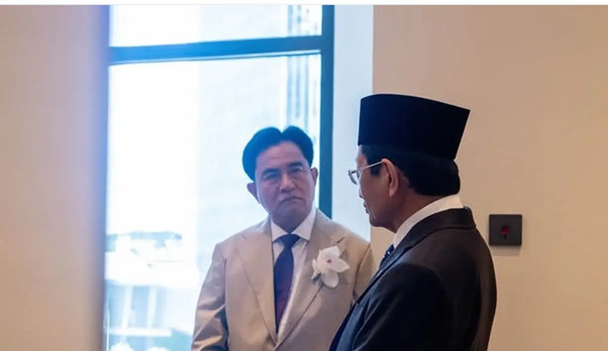 Semetara itu, sang ayah, Yusril mengenakan setelan jas warna coklat dari jas dan celana panjangnya. Dipadukan inner kemeja putih dasi warna gelap. Ditambah bros bunga putih.[@nasaruddin_umar]