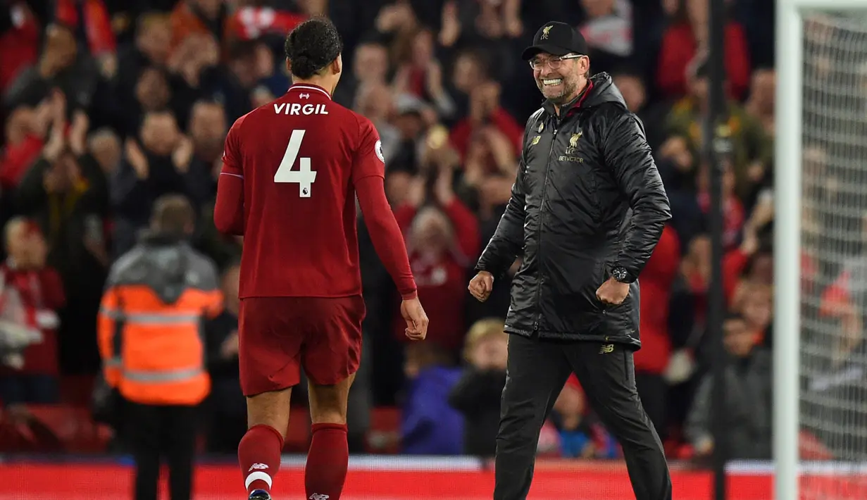 Pelatih Liverpool, Jurgen Klopp tersenyum sambil menghampiri bek Virgil van Dijk usai pertandingan melawan Everton pada lanjutan Liga Inggris di Anfield Stadium (2/11). Liverpool menang tipis atas Everton 1-0. (AFP Photo/Oli Scarff)