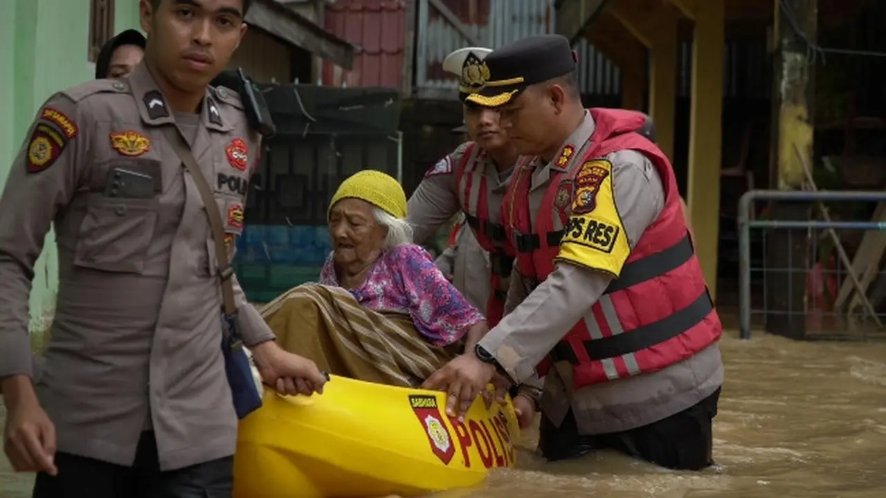 Kapolres Rokan Hulu AKBP Budi Setyono bersama anggotanya mengevakuasi lansia dari banjir.