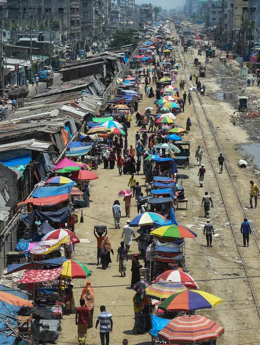 Warga memadati jalan yang dipenuhi lapak pedagang di area pasar tradisional selama karantina wilayah masih diberlakukan pemerintah setempat di Dhaka, Bangladesh (12/5/2020). (AFP/Munir Uz Zaman)
